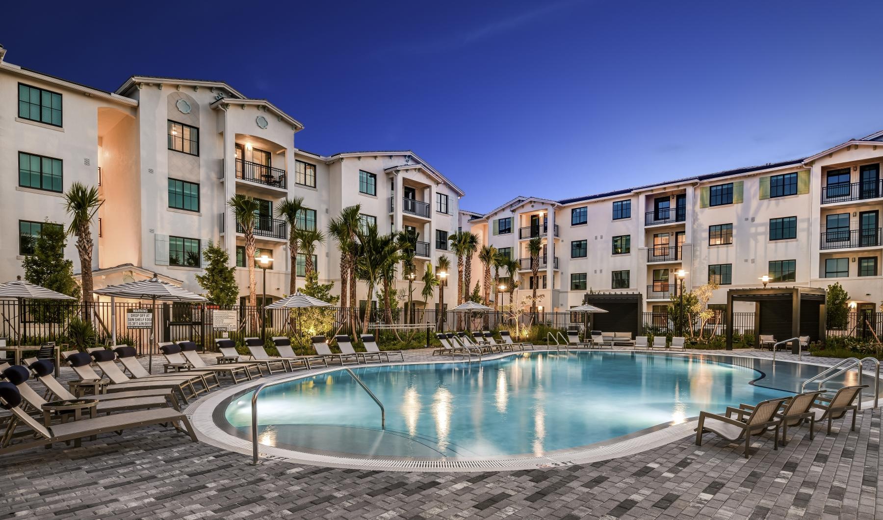 a pool in a courtyard with buildings in the background